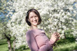 © Ekaterina Yakunina/Westend61 - Portrait of happy woman with twig of blossoming cherry tree in garden