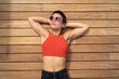 © Francesco Buttitta/Westend61 - Portrait of woman wearing sunglasses lying on wooden floor of terrace relaxing