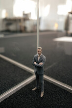 Businessman Figurine Standing Between Glass Panes