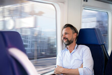 Mature Man Sitting In A Train, Looking Out Of Window