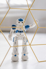 Miniature robot figurine standing behind structure