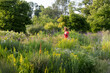 © FL/Westend61 - Woman wearing straw hat and red summer dress in garden with wildflowers