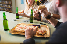 Colleagues Having Pizza And Beer In Office