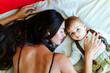 © Miguel Angel Partido Garcia/Westend61 - Young woman resting with baby boy while lying on bed