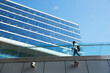 © Pete Muller/Westend61 - Businessman with backpack walking on footbridge by office building in downtown district