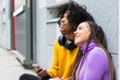 © NOVELLIMAGE/Westend61 - Smiling couple looking up while sitting against wall