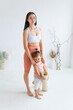 © Вадим Каштанов - Young mother with little daughter before yoga practice. Full-length portrait.