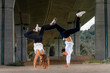 © Westend61 - Young man and woman doing handstands on road under bridge
