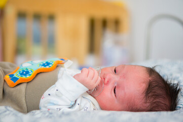 Sticker - Adorable baby boy resting in the bed