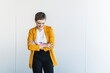 © UWE_UMSTAETTER/Westend61 - Smiling businesswoman wearing yellow blazer with arms crossed standing against wall in office