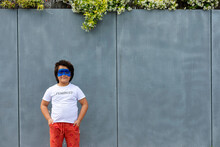 Portrait of boy with painted blue mask on his face wearing t-shirt with imprint 'Feminist'