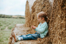 Little Girl Sitting On Straw Bales