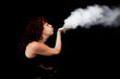 © victor espadas gonzalez/Westend61 - Woman blowing white dust while standing against black background