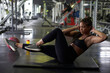 © victor espadas/Westend61 - Female athlete with hands behind head doing abdominal exercise on mat in health club