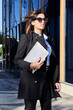 © victor espadas gonzalez/Westend61 - Businesswoman standing with laptop by financial district on sunny day