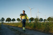© Gustafsson/Westend61 - Technician walking on field path at a wind farm with climbing equipment
