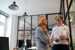 © Gustafsson/Westend61 - Businessman and businesswoman working on sticky notes at glass pane in office