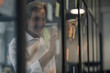 © Gustafsson/Westend61 - Senior businessman attaching adhesive notes at glass pane in office