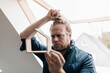 © Gustafsson/Westend61 - Architect looking through wooden house model