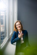 © Robijn Page/Westend61 - Successful businesswoman standing at window, holding digital tablet, laughing