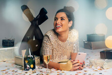 Portrait Of Young Woman Dressed For A Party, Celebrating Christmas With Gifts And Champagne