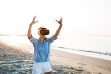 Blonde Woman Doing Kind Of Yoga Exercises On A Beach In Thailand With 3D Virtual Reality Goggles