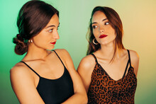 Portrait Of Two Young Women Against Green Background