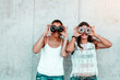 © Hannes_Eichinger/Westend61 - Two friends standing side by side looking through doughnuts