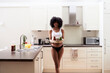 © IVAN GENER/Westend61 - Smiling young woman carrying healthy breakfast tray in kitchen