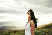 Young Woman Wearing White Dress On Viewpoint At Sunset