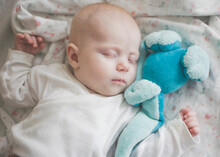 Seeping Baby Girl With A Blue Toy