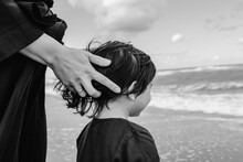 Mother's Hand Touching Little Daughter's Hair On The Beach