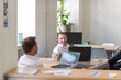 © Andreas Pacek/Westend61 - Two relaxed businessmen with laptops talking in office
