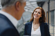 © KNSY/Westend61 - Portrait of smiling businesswoman talking to businessman in office