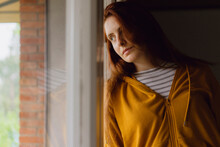 Portrait Of Redheaded Woman Looking Out Of Window