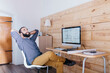 © JOSEP M ROVIROSA/Westend61 - Smiling young man sitting at desk with floor plan on the computer