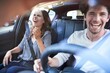 © philipp nemenz/Westend61 - Laughing couple in a car with man driving