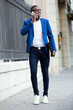 © Lifestock/Westend61 - Young businessman wearing blue suit jacket and using smartphone