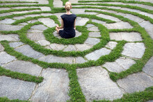 Italy, Alto Adige, Lana, Woman Sitting In Natural Open Air Maze Meditating