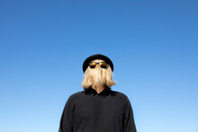 Blond Hair Covering Man's Face Wearing Sunglasses And Bowler Hat