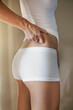 © LOUIS CHRISTIAN/Westend61 - Woman hand pinching waist skin at home