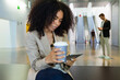 © Lifestock/Westend61 - Young businesswoman with takeaway coffee and smartphone in a foyer