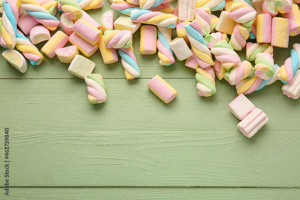 Sweet marshmallows on color wooden background