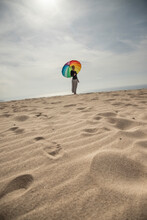 Woman With Colorful Umbrella Standing At The Beach
