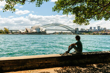 Australia, New South Wales, Sydney, Man Looking Towards The Bridge And The Sydney Opera House