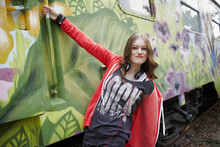 Portrait Of Teenage Girl Grimacing At A Painted Train Car