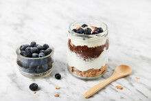 Jar Of Chia Pudding Parfait With Chocolate And Yoghurt With Blueberries And Granola