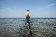 Woman Looking At Sea While Standing On Wooden Groyne At Mecklenburg, Fischland-DarÔøΩ-Zingst, Germany