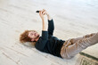 © Jo Kirchherr/Westend61 - Smiling man taking selfie through smart phone lying down on floor at home