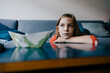 © Kniel Synnatzschke/Westend61 - Serious girl resting her head on coffee table at home